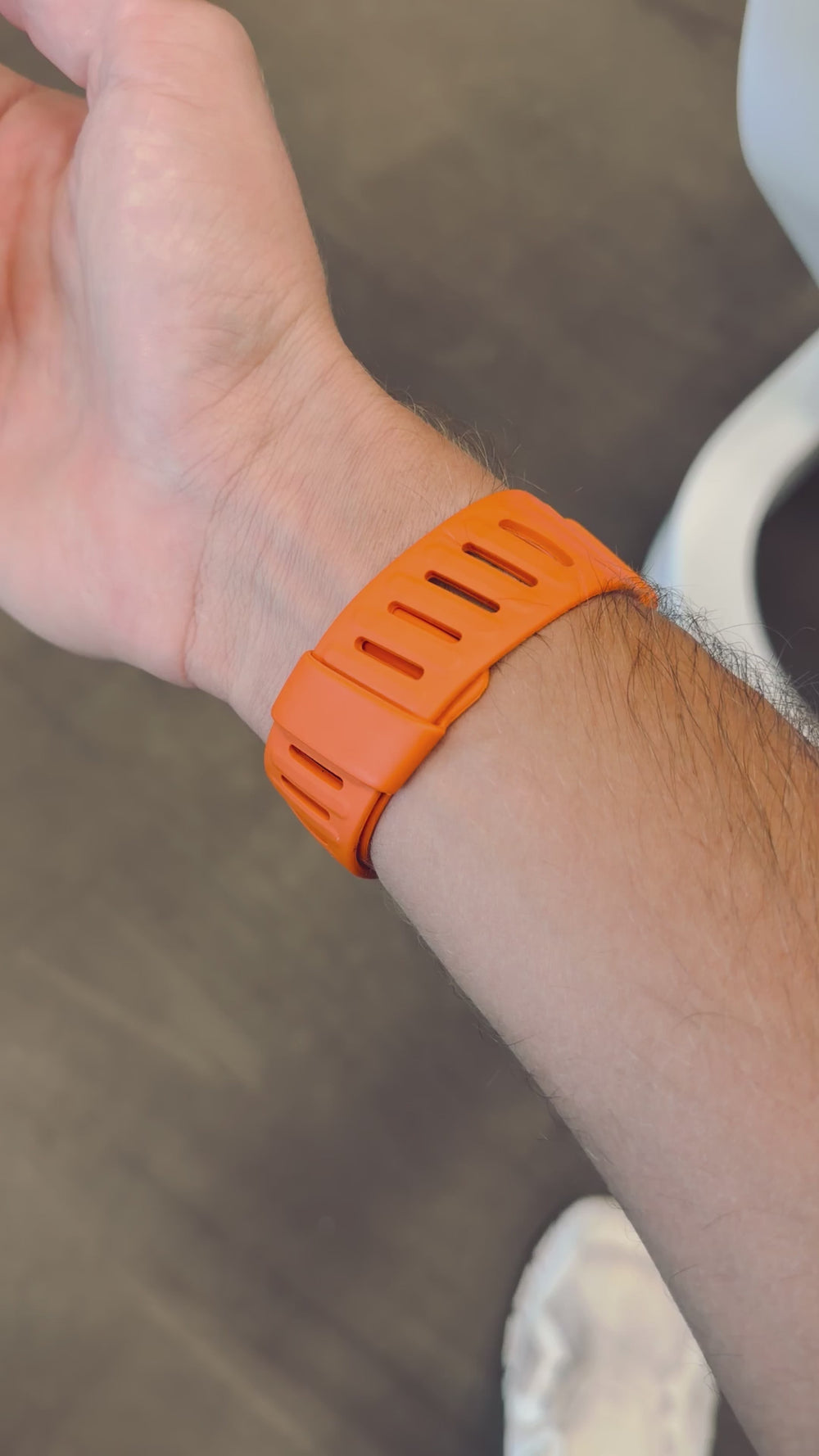 Close-up of the PulseBands orange band clasp and slots worn on the wrist